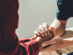 holding hands from grief and loss red sleeve and blue sleeve