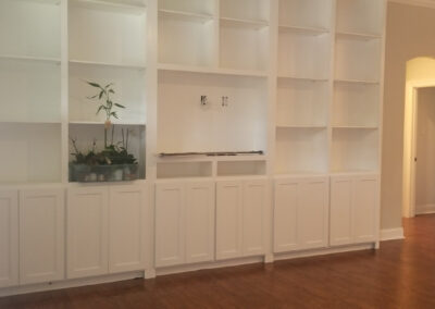 Freshly painted built-in shelving and cabinets in a restored living space.