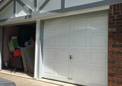 Garage exterior during renovation with updated trim and door.