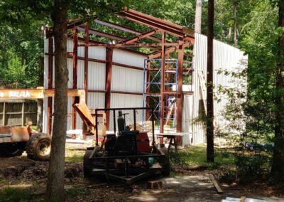 Metal outbuilding in a residential yard before cleanup, surrounded by fallen leaves.