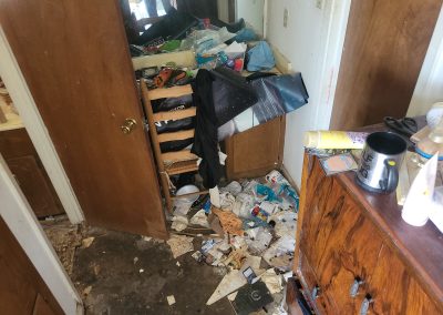 bedroom full of hoarding clutter before cleanup